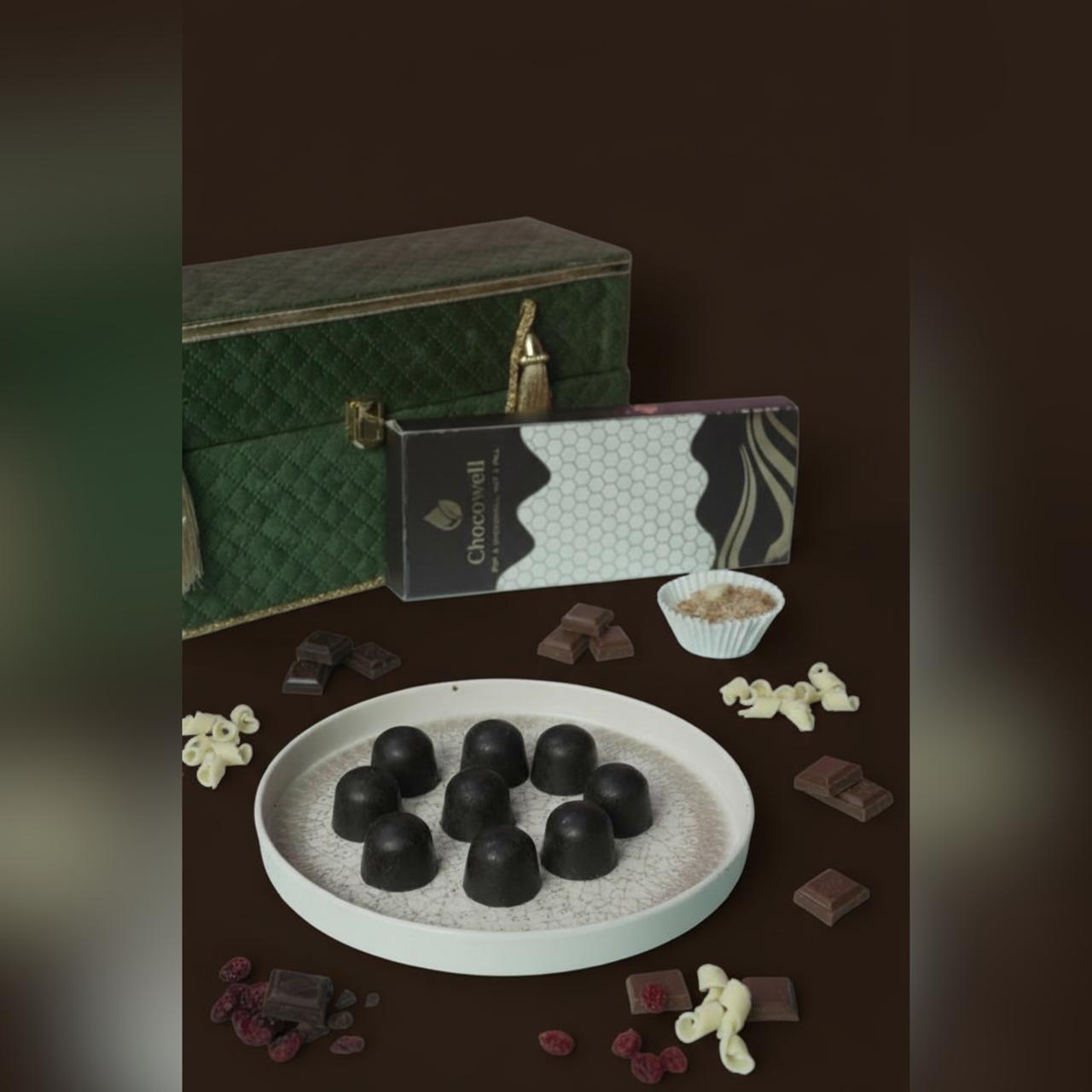 Assorted chocolates on a plate with a green box in the background